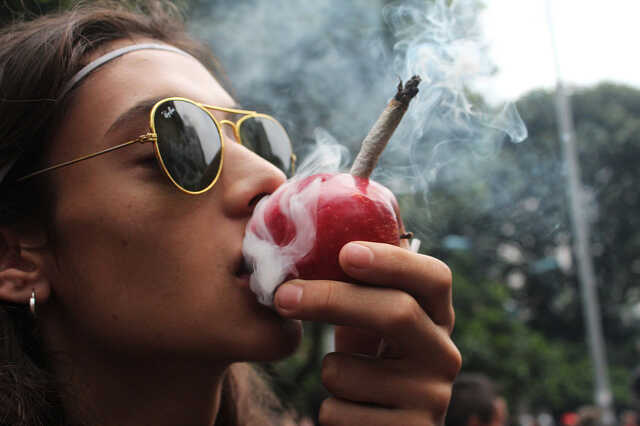 kreatív kannabiszfogyasztás: almából füvet szívó lány