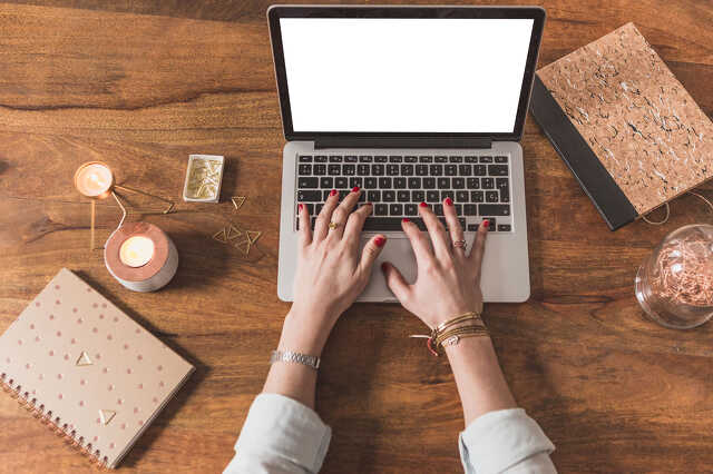 Laptop mögött dolgozó nő