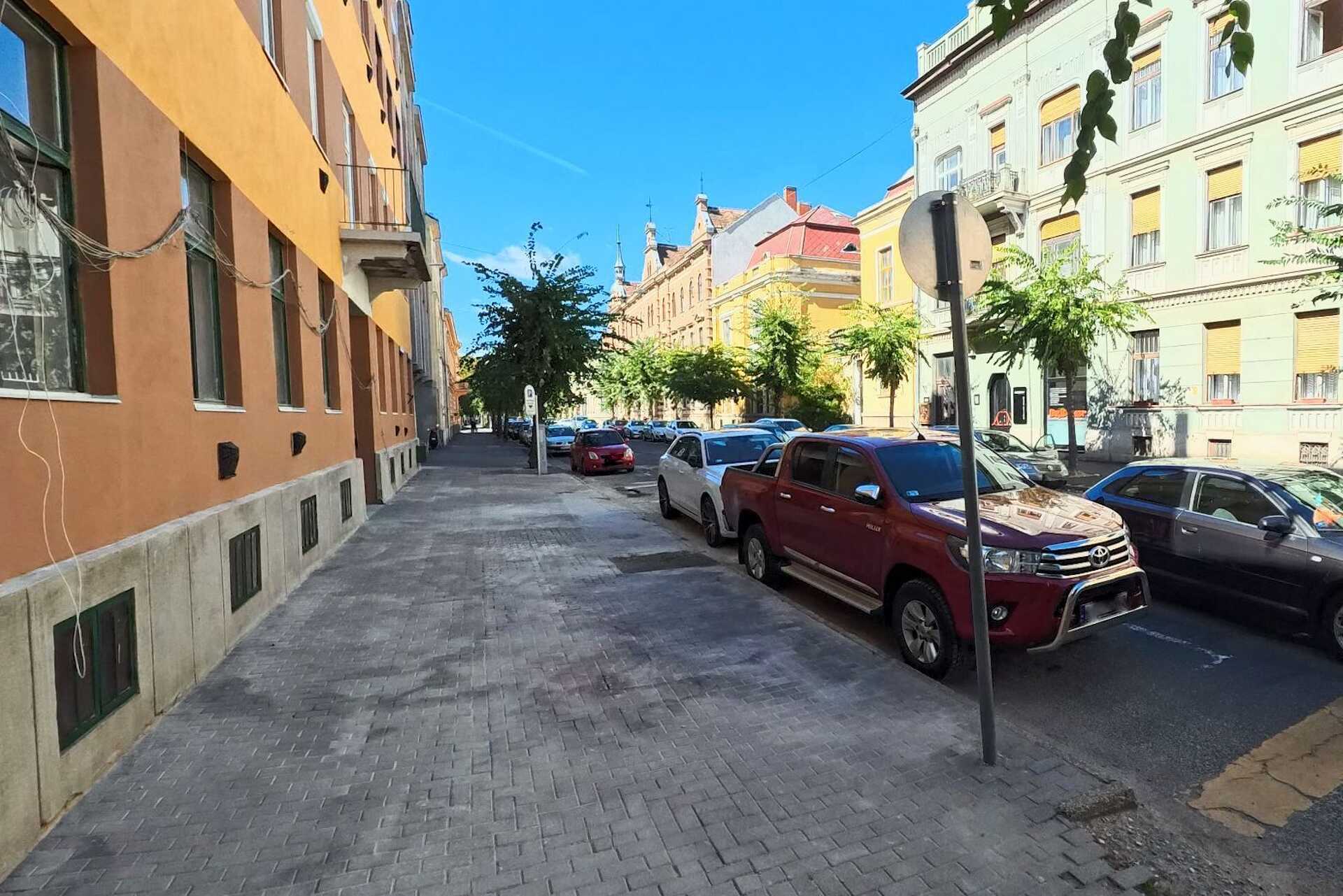 Épületfelújítás nyomai és a hátrahagyott térkőhullámok a Széll Kálmán utcában