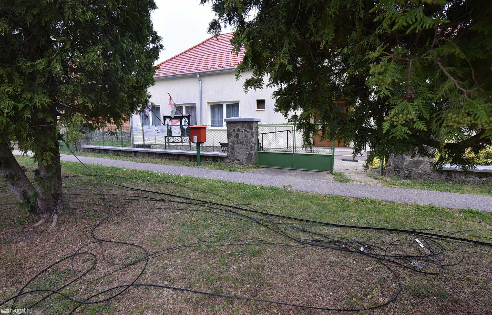 Oszlopot döntött háztetőre a beakadt telefonkábellel egy teherautó Zsédenyben