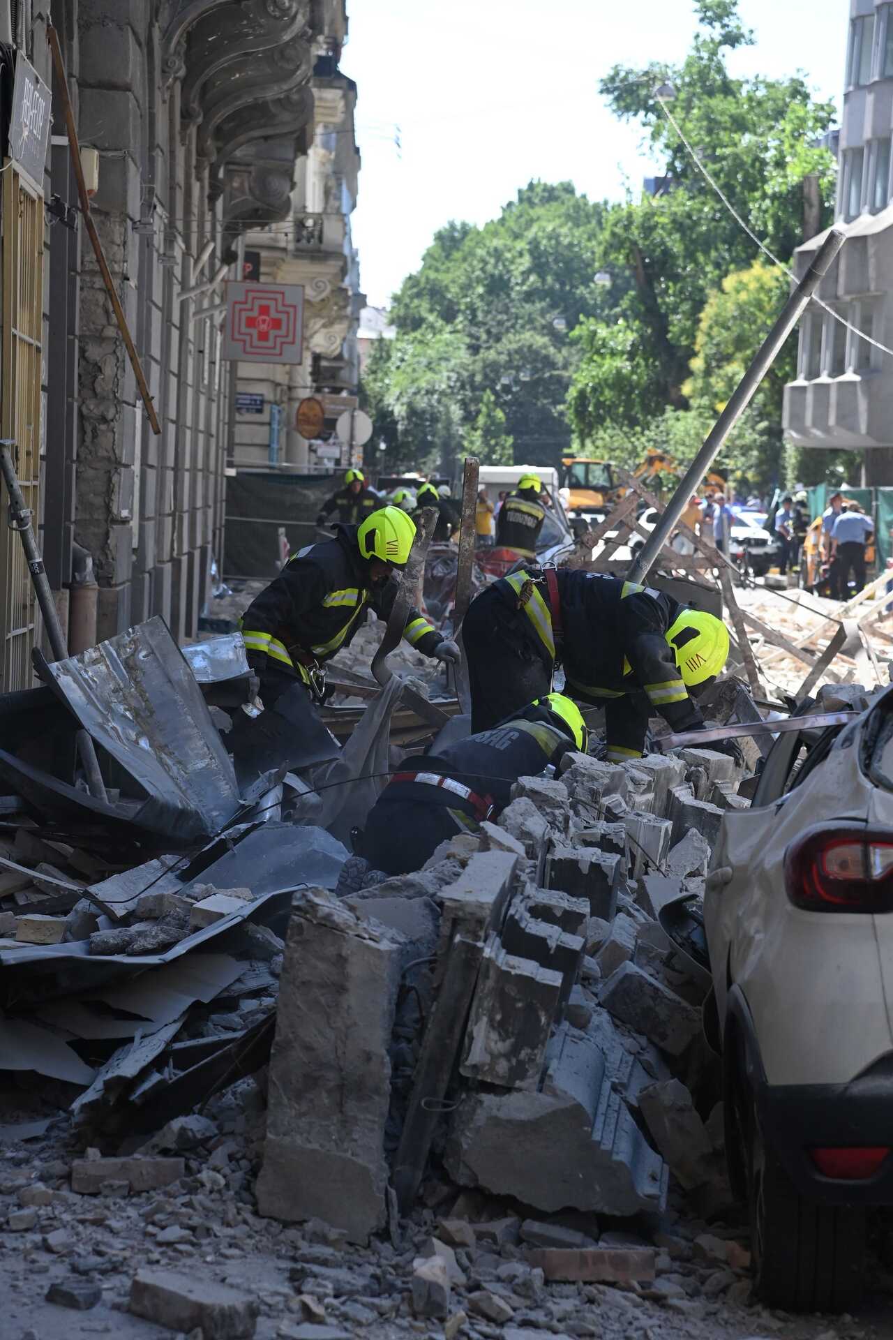 Homlokzati fal dőlt az utcára és parkoló autókra Budapest belvárosában