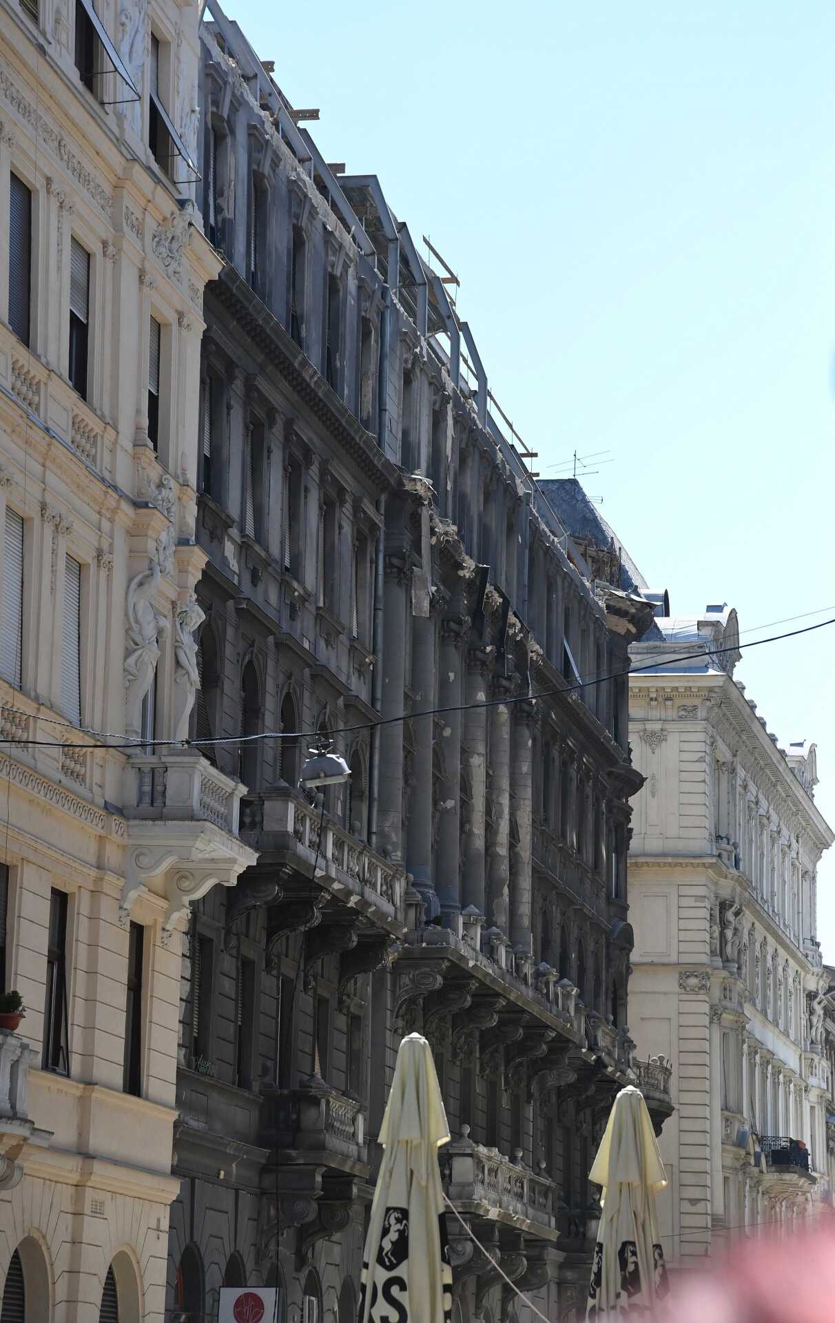 Homlokzati fal dőlt az utcára és parkoló autókra Budapest belvárosában