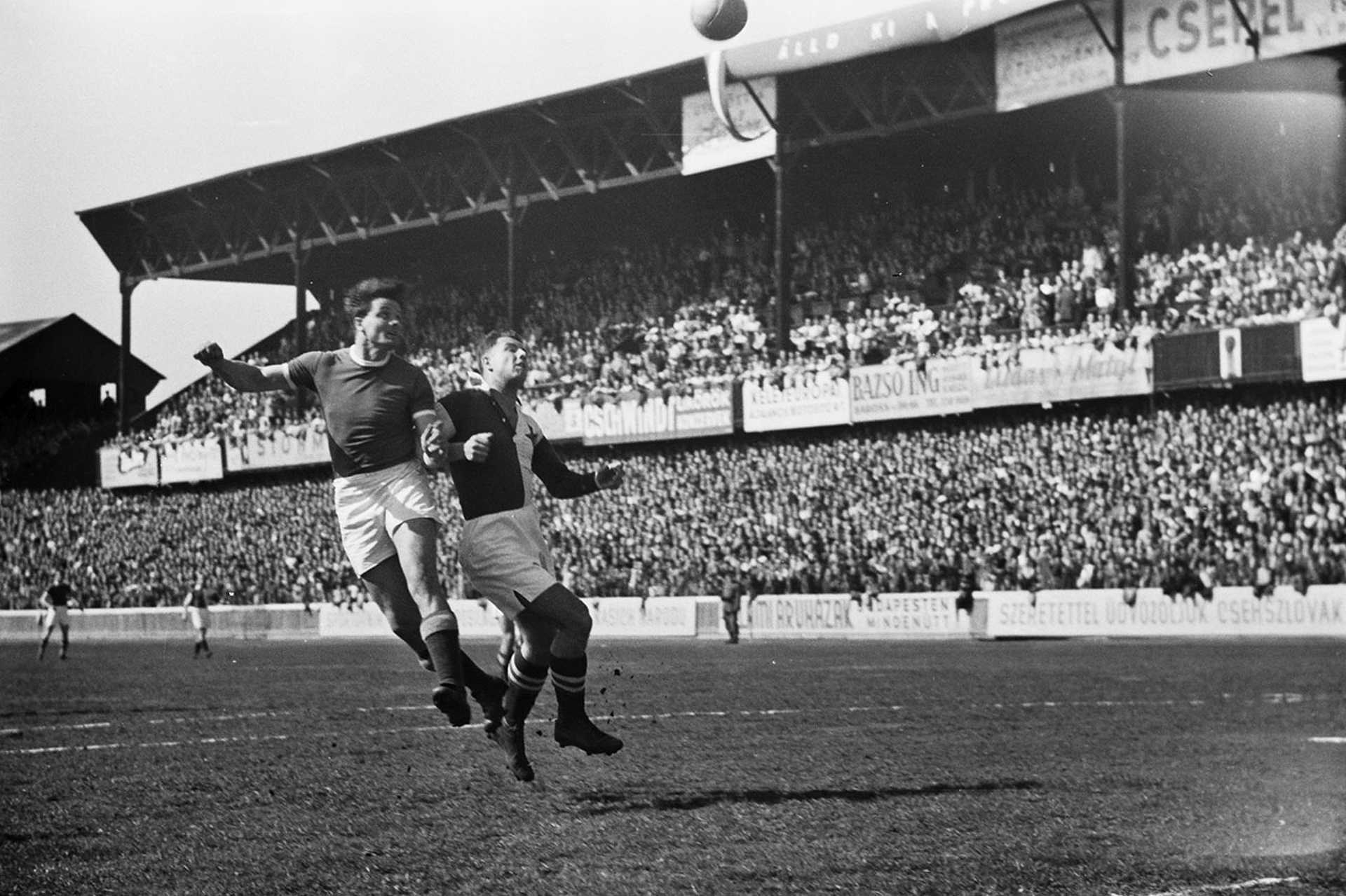 Üllői út, FTC pálya, Ferencváros - Slavia (8:3) húsvéti torna meccs, háttérben a B tribün. Deák fejel, 1949.
