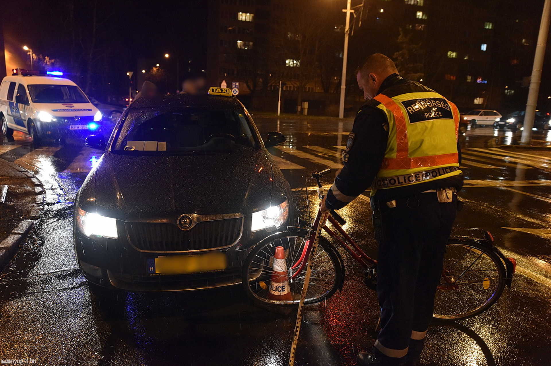Taxi elejének tekert záróvonalon keresztül egy kerékpáros