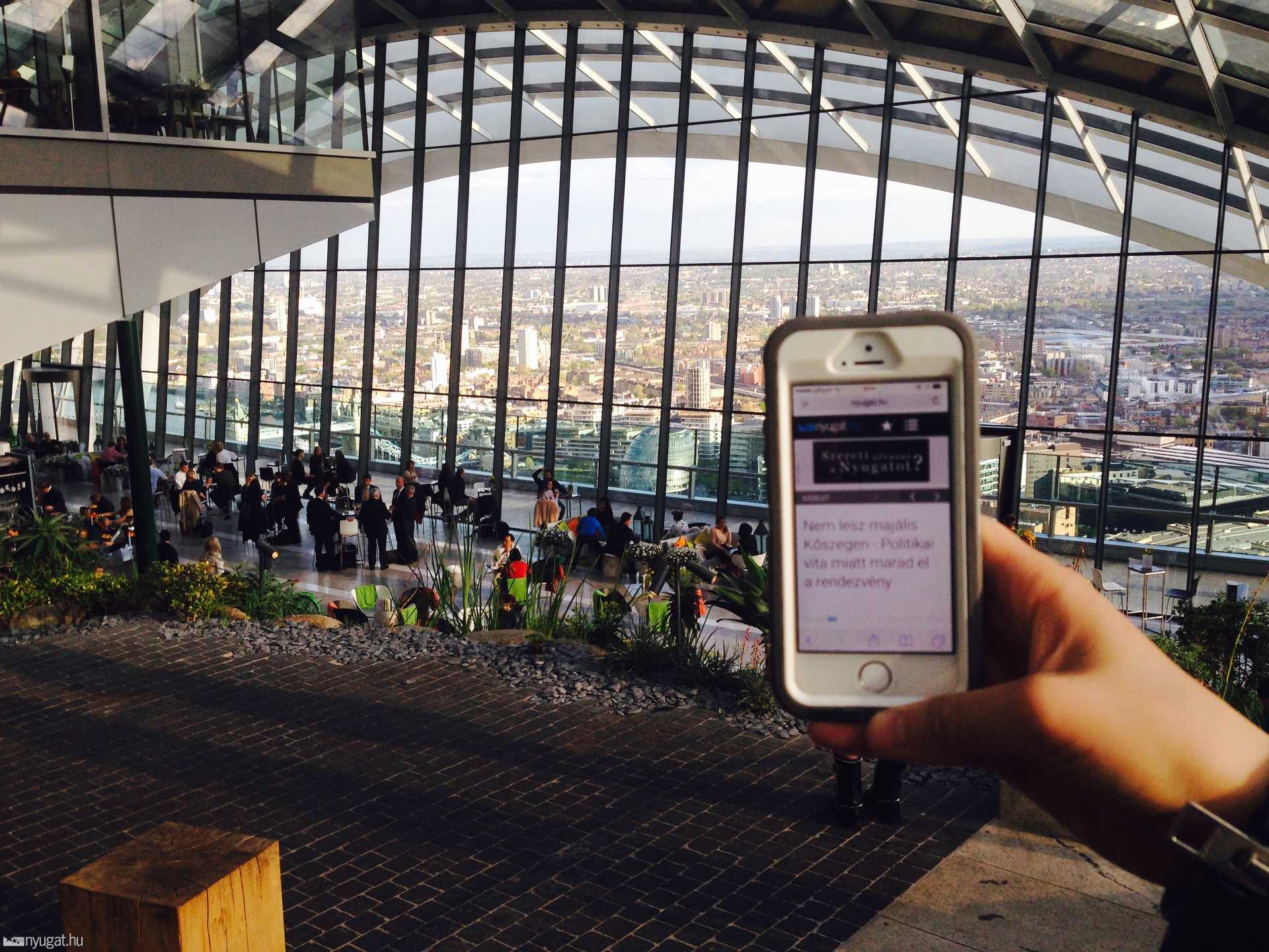 A Sky Garden a kévézó szintjéről. Bal szélen az étetrem üvegkubusának alja. Jobb széről a mobilon a Nyugat.hu:) 