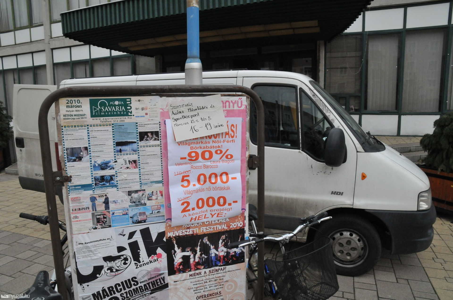 Az MSH előtt parkolt a kereskedők járműve, előtérben egy reklámplakátjuk